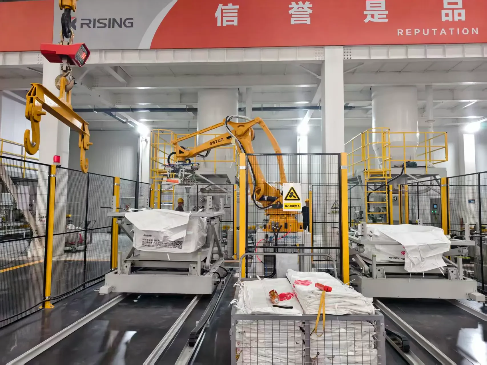 ذراع روبوتية تناول أكياس مواد حرارية مونوليثية في قاعدة التصنيع الآلية التابعة لـ RISING REFRACTORY
